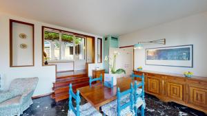 a living room with a wooden table and blue chairs at Villa Elvira in San Felice del Benaco