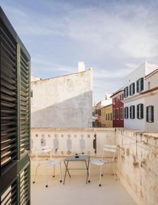 a patio with chairs and a table on a building at Hotel Hevresac Singular & Small in Mahón