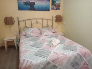 アルコス・デ・ラ・フロンテーラにあるCasas Lomas IIのベッドルーム1室(ピンクと白のベッド1台、タオル2枚付)