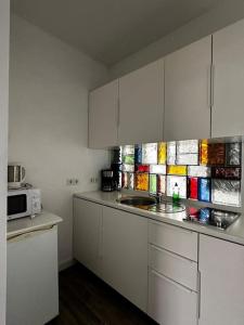 a kitchen with white cabinets and a microwave at Nice flat in Berlin 10 in Berlin