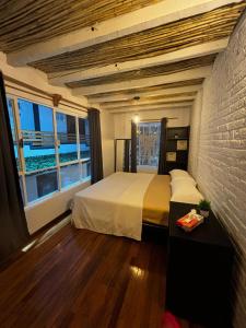 a bedroom with a bed and a brick wall at Casa Columpio in Mexico City