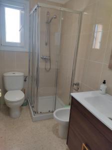a bathroom with a shower and a toilet and a sink at Casa Laya en Oliva Nova in Oliva