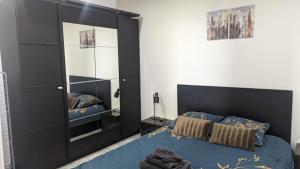 Un dormitorio con un gran armario negro y una cama en Domaine de la Griffe - Appartement moderne à la montagne en La Roche-sur-Foron