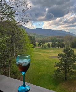 a glass of wine sitting on a table with a view at Mt Mitchell Cabin Rentals in Busick