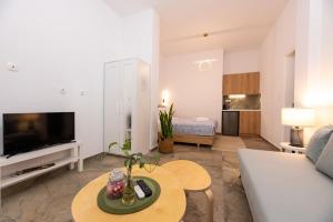 a living room with a couch and a table at Valhalla - Brand New Airport Apt. in Spáta