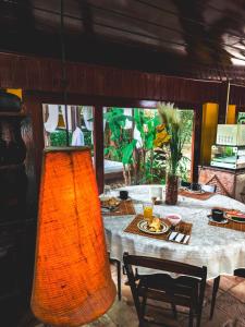 una mesa de comedor con una luz naranja colgando sobre ella en Pousada Point Beach en Guarujá