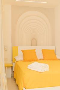 ein Schlafzimmer mit einem Bett mit einer orangefarbenen Decke in der Unterkunft La Chicca Apartments Castellammare Di Stabia in Castellammare di Stabia