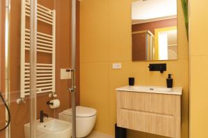 ein Badezimmer mit Waschbecken, Toilette und Spiegel in der Unterkunft La Chicca Apartments Castellammare Di Stabia in Castellammare di Stabia + 49 Fotos