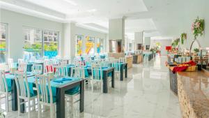Get Enjoy Hotels في بيلديبي: مطعم بطاولات وكراسي زرقاء وبيضاء