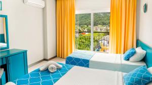 Get Enjoy Hotels في بيلديبي: غرفة نوم بسريرين ونافذة ذات ستائر برتقالية