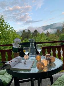 a table with wine glasses and a book on a balcony at Apartman Lana in Jajce
