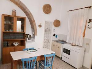 a kitchen with a table and blue chairs at Casa Ernesto in Pisticci
