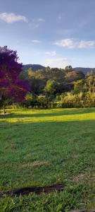 a field of grass with trees in the background at Recanto das Flores in São Thomé das Letras
