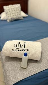 - une serviette blanche sur un lit avec des insignes en aania dans l'établissement Alojamiento laureles estadio medellin, à Medellín