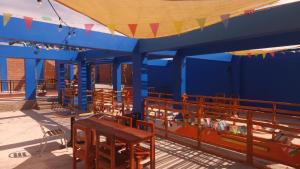 un grupo de mesas y sillas bajo una tienda azul en Raymi House Hostel, en Arica