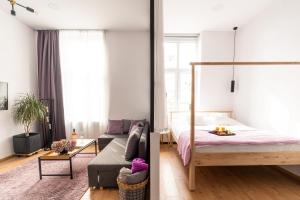 - une chambre et un salon avec un lit et un canapé dans l'établissement Urban Six Apartments, à Făgăraş