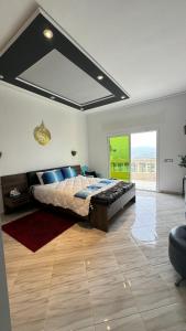a bedroom with a large bed and a large window at La Perla Montaña Tanger in Tangier