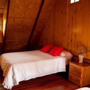 奧克薩潘帕的住宿－Cemayu Lodge，一间卧室配有一张带两个红色枕头的床