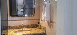 een badkamer met een wastafel en een spiegel bij Casa de Hospedagem Uberaba in Uberaba