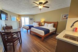 a hotel room with two beds and a sink at Pointes North Beachfront Hotel - 2 Person Spa Tub Studios in Traverse City