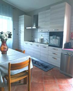 羅馬的住宿－Apartment Roma Tor Vergata con Giardino，厨房配有桌子和花瓶