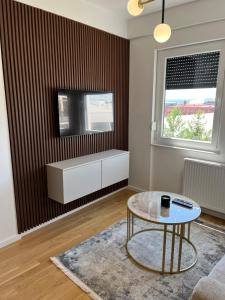 sala de estar con mesa de centro y TV en Green Lux Apartman Prijedor, en Prijedor