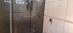 een badkamer met een glazen douche met toilet bij Casa de Hospedagem Uberaba in Uberaba