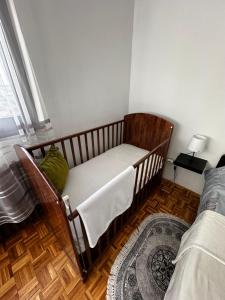 a small bedroom with a crib in the corner at TAMARIS Apartment in Subotica