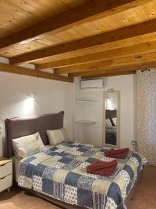 um quarto com uma cama com um cobertor xadrez azul e branco em Hamre Apartments (Nicholas) em Agios Georgios Pagon