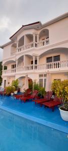 ein Hotel mit einem Pool mit Stühlen und Sonnenschirmen in der Unterkunft Taboga Palace SPA Hotel in Taboga
