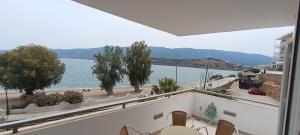 un balcón con vistas a un cuerpo de agua en New Aegli Resort Hotel en Poros
