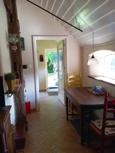 een keuken met een tafel en een eetkamer met een deur bij Onder de Linde, Rust, Natuur en Privacy in Benneveld