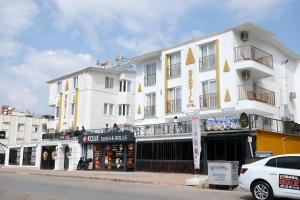 un grand bâtiment blanc avec un magasin devant lui dans l'établissement Babil Hotel, à Antalya