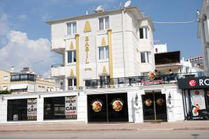un bâtiment blanc avec une pizzeria en face de lui dans l'établissement Babil Hotel, à Antalya