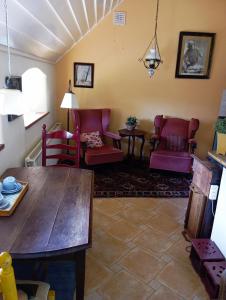 een woonkamer met rode stoelen en een houten tafel bij Onder de Linde, Rust, Natuur en Privacy in Benneveld