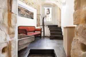 ラグーザにあるItria Palaceの階段、ソファ、窓が備わる客室です。
