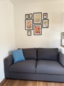- un canapé bleu dans le salon avec des photos sur le mur dans l'établissement Apartment Adriana, à Muggia