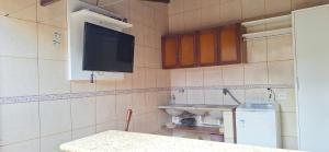 een kleine keuken met een tv aan de muur bij Casa de Hospedagem Uberaba in Uberaba +7 foto's