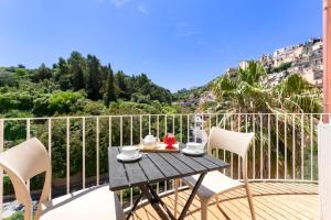 una mesa y sillas en un balcón con vistas en Itria Palace en Ragusa