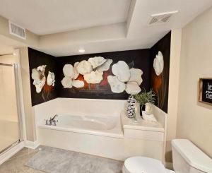 a bathroom with a tub and a painting of flowers at Seaside Treasure in Biloxi +12 photos