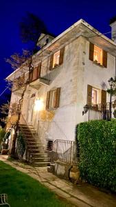 Un grand bâtiment blanc avec des escaliers se trouve juste devant. dans l'établissement B&B Villa Moro - Family House, à Domodossola