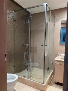 une salle de bain avec une douche avec des toilettes et un lavabo dans l'établissement Plage des nations, à Sale 5 autres photos