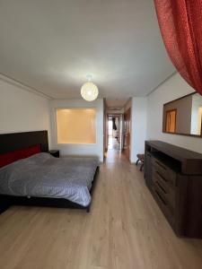 une chambre avec un lit, une commode et un miroir dans l'établissement Plage des nations, à Sale