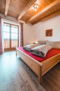 1 dormitorio con 1 cama grande de madera en una habitación en Almresidenz Unterrain zum Hartl -1 km BY CAR DISTANCE SKI SLOPES KRONPLATZ, en Valdaora