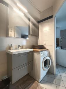 a bathroom with a washing machine and a sink at Studio cosy vue mer Canet Plage 3étoiles in Canet-en-Roussillon