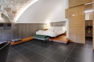 a bedroom with a bed and a bench in a room at Itria Palace in Ragusa