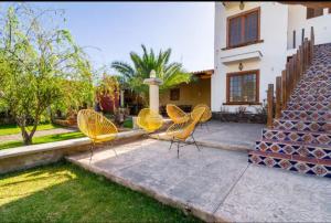 Drei gelbe Stühle stehen vor einem Haus in der Unterkunft Villa Isabela 10 Sleeps - Pool - Huge garden in Cuyutlán