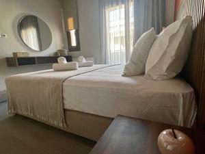 a bedroom with a large bed with a mirror at Αura Luxury Apartments in Ierissos