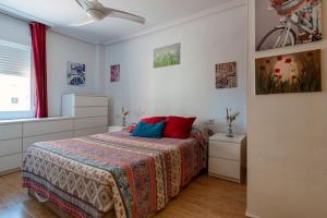 una camera da letto con un letto con cuscini rossi e blu di Apartment in La Manga a La Manga del Mar Menor Altre 26 foto