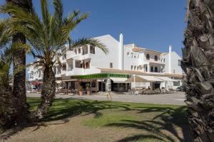 un grande edificio bianco con palme di fronte di Apartment in La Manga a La Manga del Mar Menor